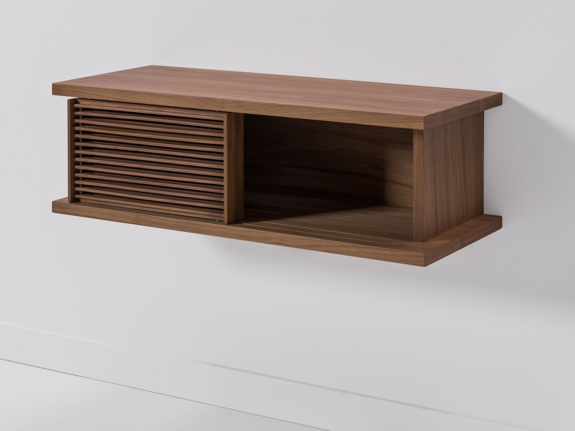 Small walnut floating media unit with slatted doors front angle view